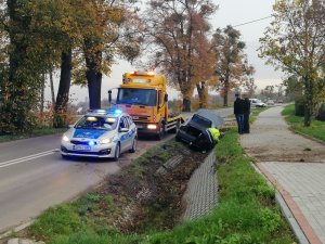 Trasa Kwidzyn Rozpędziny widoczny radiowóz z włączoną sygnalizacją i samochód w rowie. Na miejscu widoczny jest także samochód pomocy drogowej.