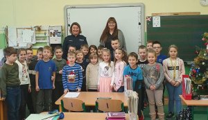 zdjęcie przedstawia funkcjonariuszkę policji i wychowawczynię wraz z uczniami klasy pierwszej, wszyscy stoją przed tablicą