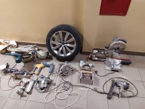 zdjęcie przedstawia różnego rodzaju elektronarzędzia i koło od samochodu wszystko to zostało odzyskane przez policjantów