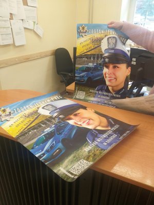 zdjęcie plakatu promocyjnego zachęcającego do wstąpienia w szeregi policji leżącego na biurku w sekretariacie szkoły