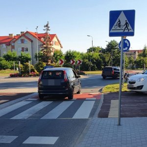 zdjęcie ronda w Kwidzynie wjeżdża na nie czarny samochód na chodniku widać fragment białego auta