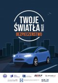 plakat promujący do akcji twoje światła nasze bezpieczeństwo, na granatowym tle widać na ulicy białe auto z włączonymi światłami w tle budynki.