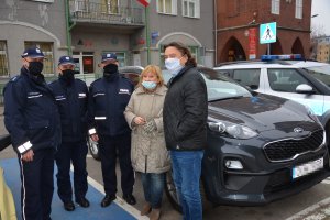 zdjęcie przedstawia trzech umundurowanych funkcjonariuszy stojących obok nowego nieoznakowanego radiowozu który został im przekazany przez burmistrza gminy i miasta Prabuty Marka Szulca i główną księgową Elżbietę Wykner