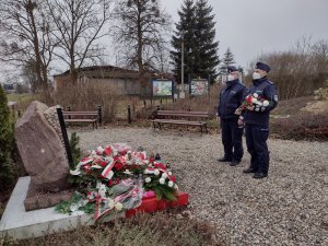zdjęcie zrobione dwóm komendantom w niebieskich mundurach przed pomnikiem poświęconym pamięci Żołnierzy Wyklętych na Skwerze im. Konfederatów Obrony Wiary i Ojczyzny przy ul. Długiej w Marezie, którzy mają tam złożyć kwiaty.