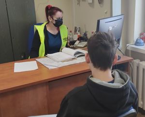 Zdjęcie przedstawia policjantkę wydziału Dochodzeniowo-Śledczego oraz zatrzymanego mężczyznę podczas czynności przesłuchania.