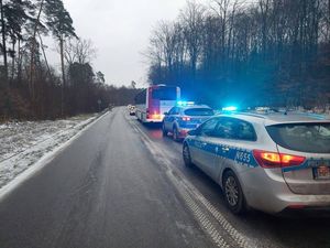 na zdjęciu widać oblodzoną ulicę na jednym pasie ruchu stoi samochód osobowy w którego tył wjechał autobus za nimi dwa radiowozy policyjne