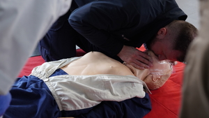 na zdjęciu widać policjanta który na fantomie uczy się przeprowadzać resuscytację krążeniowo oddechową