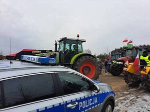 na zdjęciu widać radiowóz oraz traktory przygotowujące się do wyjazdu na protest