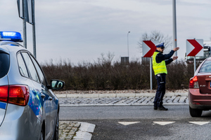 na zdjęciu widać policjanta który stoi na rondzie i kieruje ruchem