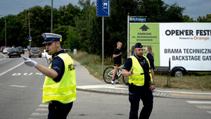 na zdjęciu widać dwóch policjantów kierujących ruchem na ulicy