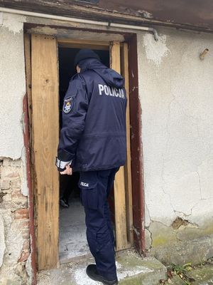 umundurowany policjant wchodzi do pustostanu