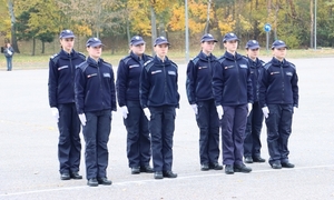 grupa ośmiu policjantów stojących w dwuszeregu na placu apelowym