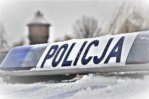 zaśnieżony dach radiowozu na którym jest napis policja