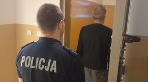 na zdjęciu widać stojącego w wejściu do celi umundurowanego funkcjonariusza i mężczyznę zatrzymanego do sprawy dotyczącej jazdy samochodem pomimo zasądzonych sześciu zakazów prowadzenia pojazdów