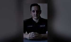 policjant siedzący przy biurku