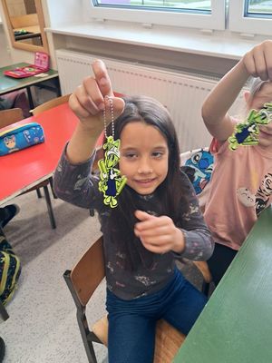 na zdjęciu widać uśmiechnięte dziewczynki które trzymają w dłoniach odblaski