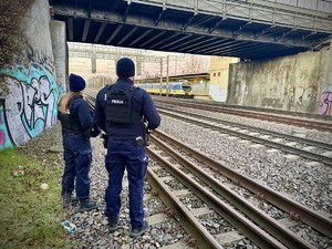 na zdjęciu widać stojących policjantów dwie osoby w pobliżu torowiska