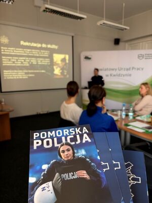 na zdjęciu widać funkcjonariuszkę która prowadzi spotkanie dotyczące doboru do policji zdjęcie obejmuje uczestniczki i ulotki które trzyma w ręku fotograf