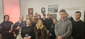 na zdjęciu widać grupę młodzieży która złożyła dokumenty do tego by wstąpić do służby w policji osoby te stoją w grupie kila z nich ma w ręku ulotki wśród młodzieży jest troje policjantów w mundurach