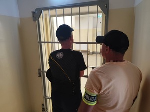 Zdjęcie zatrzymanego prowadzonego przez policjanta operacyjnego