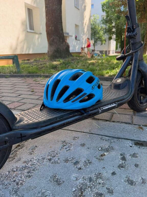 na zdjęciu widać hulajnogę elektryczną na której położny jest kask