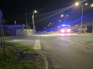 na zdjęciu widać miejsce zdarzenia wóz strażacki oświetlone dwa przejścia dla pieszych i uszkodzony po wypadku rower leżący na poboczu